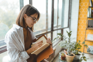 Woman journaling in a leather-bound notebook.