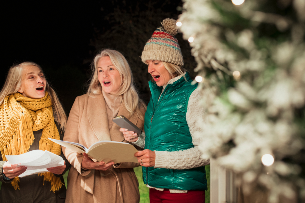 Three women Singing Christmas carols together.