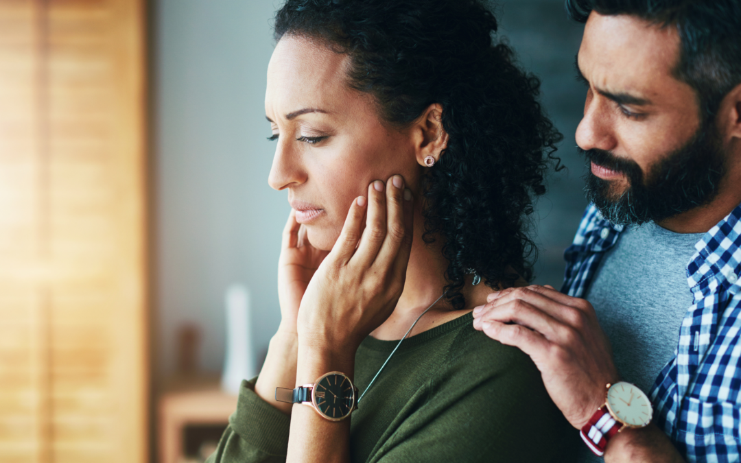 Man comforting a distressed woman at home, showing emotional support and empathy in a relationship.